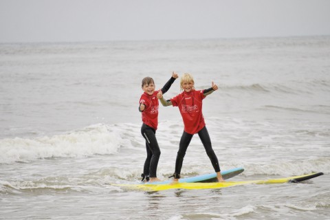 Surfen met Quiksilversurfschool DJUS De Jongens Uit Schoorl op een surfplank